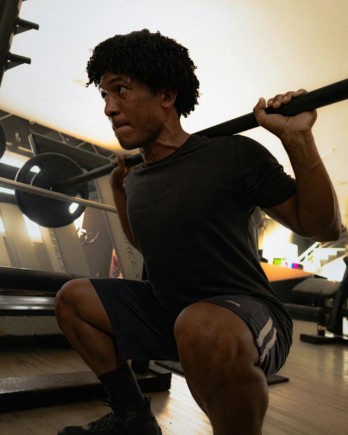 Man performing a barbell squat during a strength training session